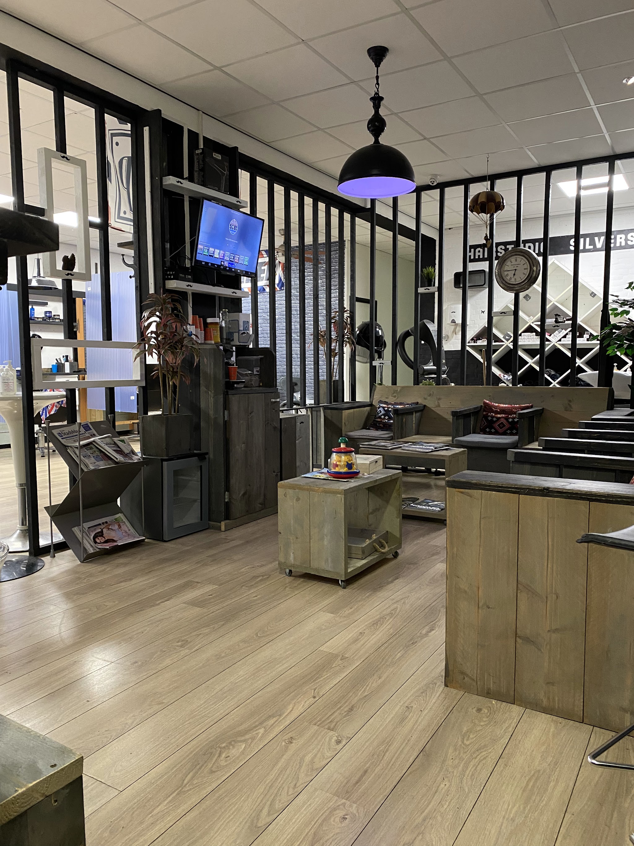 Het interieur van de zaak met de werkplekken en de wachtruimte